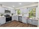 Modern kitchen with gray cabinets, stainless steel appliances, quartz counters, and a window seat at 1911 Rollingwood Se Dr, Atlanta, GA 30316