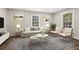 Cozy living room with neutral tones, hardwood floors, comfortable seating, and bright natural light from large windows at 1911 Rollingwood Se Dr, Atlanta, GA 30316