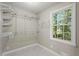 Walk-in closet with custom shelving and a window for natural light at 1911 Rollingwood Se Dr, Atlanta, GA 30316
