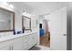 Bathroom featuring dual vanity, white cabinets, and an open doorway to the bedroom at 300 Olmstead Way, Alpharetta, GA 30022
