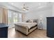 Spacious bedroom with a tufted bed, tray ceiling, and access to a balcony through glass doors at 300 Olmstead Way, Alpharetta, GA 30022