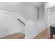 Well-lit hallway with white wainscoting and hardwood floors leading to a bedroom and staircase at 300 Olmstead Way, Alpharetta, GA 30022