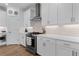 White kitchen with a stainless steel range hood and plenty of countertop space and modern appliances at 300 Olmstead Way, Alpharetta, GA 30022