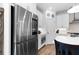 Modern kitchen featuring stainless steel refrigerator, white cabinets, countertops and eat at island at 300 Olmstead Way, Alpharetta, GA 30022