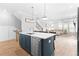 Open-concept kitchen features an island with a sink and dishwasher; with view into the living area at 300 Olmstead Way, Alpharetta, GA 30022