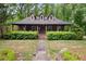 Charming brown home featuring dormer windows and a quaint front porch with meticulously manicured landscaping at 68 Edwin Pl Nw, Atlanta, GA 30318