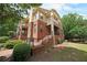 Beautiful exterior elevation of a brick home featuring a private balcony, stylish trim, and lush landscaping at 718 Province Se Pl, Atlanta, GA 30312