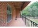 Charming porch with brick floor and black iron railing with view of trees at 718 Province Se Pl, Atlanta, GA 30312