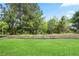 Lush backyard showcases mature trees, a green lawn, and tasteful landscaping at 3322 Grace Farm Ln, Buford, GA 30519