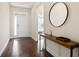 Bright entryway with hardwood floors, console table, and a round mirror at 3322 Grace Farm Ln, Buford, GA 30519