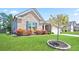 Beautifully landscaped front yard of a brick home with a young tree at 3322 Grace Farm Ln, Buford, GA 30519