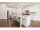 Spacious kitchen with dark wood floors, large center island, stainless steel fridge, and modern lighting at 3322 Grace Farm Ln, Buford, GA 30519
