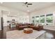 Open-concept living room with modern furniture, hardwood floors, and a view to the kitchen at 3322 Grace Farm Ln, Buford, GA 30519