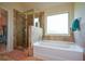 Bathroom features a walk-in shower, a soaking tub, and a window for natural light at 6816 Diamond Dr, Rex, GA 30273