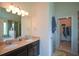Bathroom features a double sink vanity, a shower, and an access door to a walk-in closet at 6816 Diamond Dr, Rex, GA 30273