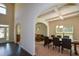 Open-concept dining area with coffered ceilings, arched entryways, and views into the living spaces at 6816 Diamond Dr, Rex, GA 30273