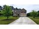 Two-story home with a two-car garage, tidy landscaping, and a long concrete driveway at 6816 Diamond Dr, Rex, GA 30273