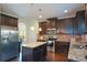 Modern kitchen with dark cabinets, stainless steel appliances, granite countertops, and a kitchen island at 6816 Diamond Dr, Rex, GA 30273