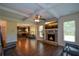 Cozy living room featuring a stone fireplace, exposed beam ceilings, hardwood floors, and an open floor plan at 6816 Diamond Dr, Rex, GA 30273
