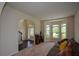 Bright living room features large bay windows, an arched doorway, and neutral decor, perfect for entertaining at 6816 Diamond Dr, Rex, GA 30273
