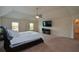 Bright main bedroom with a ceiling fan, a mounted television, and several windows at 6816 Diamond Dr, Rex, GA 30273