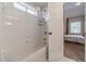 Bright bathroom featuring a shower-tub combo with white tiled walls at 1032 Jordan Rd, Dacula, GA 30019