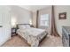 Cozy bedroom with a patterned bedspread, neutral walls, and natural light at 1032 Jordan Rd, Dacula, GA 30019