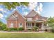 Charming two-story brick home with a welcoming front porch and beautifully landscaped front yard at 1032 Jordan Rd, Dacula, GA 30019