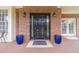 Charming brick home entrance with a black front door flanked by blue potted plants and wall-mounted coach lights at 1032 Jordan Rd, Dacula, GA 30019