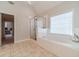 Bright main bathroom featuring a soaking tub, a glass enclosed shower and large windows at 1032 Jordan Rd, Dacula, GA 30019