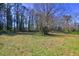A spacious backyard with tall trees on a sunny day at 118 Ingleside Dr, Jonesboro, GA 30236