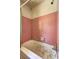 Pink-tiled bathroom with a stained tub, shower head, and dated fixtures at 118 Ingleside Dr, Jonesboro, GA 30236