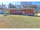 An eye-level view of a charming one-story brick home with a well-maintained front lawn at 118 Ingleside Dr, Jonesboro, GA 30236