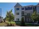 Charming townhome showcasing a blend of white and brick facade, complemented by landscaped front yard at 1899 Deco Dr, Kennesaw, GA 30144