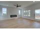 Bright living room with an electric fireplace, light wood flooring and multiple windows at 1899 Deco Dr, Kennesaw, GA 30144