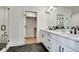 Beautiful bathroom with dual sinks, white cabinets, black hardware, herringbone floor, and glass enclosed shower at 625 Home Se Ave, Atlanta, GA 30312