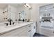 Bright bathroom featuring dual sinks, white cabinets, marble countertop, and a view to the bedroom at 625 Home Se Ave, Atlanta, GA 30312