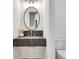 Stylish powder room featuring a sleek floating vanity with dark stone countertop and oval mirror at 625 Home Se Ave, Atlanta, GA 30312