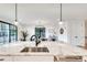 Close-up of kitchen island featuring a marble countertop, stainless steel sink, and modern pendant lighting at 625 Home Se Ave, Atlanta, GA 30312