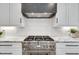 Gourmet kitchen showcases stainless steel appliances, a range hood, marble countertops, and custom white cabinets at 625 Home Se Ave, Atlanta, GA 30312