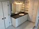 Bathroom featuring white cabinets, dark countertop, single sink, and storage cabinets, creating a functional design at 870 Thornberry Dr, Alpharetta, GA 30022