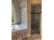 Bathroom showcasing soaking tub, glass block privacy window, and separate glass shower with marble tile at 870 Thornberry Dr, Alpharetta, GA 30022