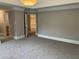 Large bedroom featuring neutral gray walls, soft carpeting, and an open doorway to the hallway, enhancing the sense of space at 870 Thornberry Dr, Alpharetta, GA 30022