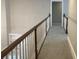 Upstairs hallway with neutral carpet and a white railing, providing a safe and stylish transition between rooms at 870 Thornberry Dr, Alpharetta, GA 30022
