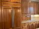 Gourmet kitchen showcasing a built-in refrigerator, custom wood cabinets, and granite countertops with backsplash at 870 Thornberry Dr, Alpharetta, GA 30022