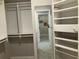 Walk-in closet with custom shelving and a mirrored wall, maximizing storage and style at 870 Thornberry Dr, Alpharetta, GA 30022