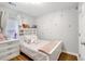 Bedroom featuring a cozy bed, dresser, and a window with sheer curtains at 1029 Megan Ct, Sugar Hill, GA 30518