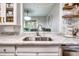Bright white kitchen featuring quartz countertops, stainless sink, and decor at 1029 Megan Ct, Sugar Hill, GA 30518