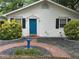Inviting home exterior showcasing a vibrant blue front door, complemented by black shutters, bird bath, and a charming brick walkway at 1311 Sylvan Cir, Brookhaven, GA 30319