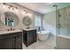 Modern bathroom with dual vanities, round mirrors, standalone tub and sleek, glass-enclosed shower at 1885 Vintage Dr, Snellville, GA 30078